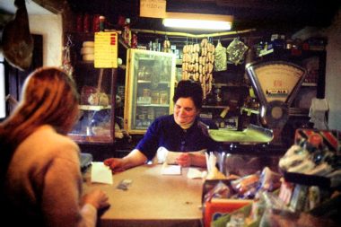 Eine Matrone als Verkäuferin bedient eine junge Frau als Kundin in einem alten Tante Emma Laden in der Toscana in Italien